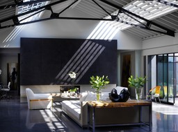 Warehouse conversion with high ceilings, beams and an industrial feel, contrasting black and white.